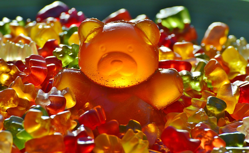 A giant gummy bear surrounded by other tiny gummy bears
